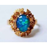 A modern 9ct gold and opal ring, the single oval stone measures 9mm by 7mm in a foliate setting,