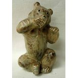 A Royal Copenhagen stoneware model of a seated bear licking its right paw, coffee cream colourway,