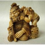 A fine Japanese ivory Okimono, 19th century, a seated warrior sleeping, holding his sword with an