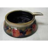 A Moorcroft pottery ash tray of circular form with silver plated rim and cigarette holder,