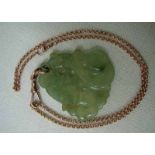 An oriental celadon green jade pendant, openwork design depicting mythical fish on a 9ct rose gold