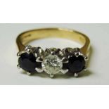 An 18ct gold three stone sapphire and diamond ring, the central diamond 0.4carat approx flanked by a