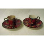 A pair of early 20th century William Moorcroft pottery coffee cans and saucers, tubeline decorated