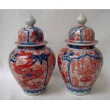 A pair of Imari ginger jars of typical form, lidded, decorated in blue and red with panels of