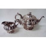 A George IV Regency silver teapot of squat cylindrical melon form, heavily embossed with foliage,