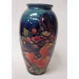 A Moorcroft pottery vase of baluster form, tubeline decorated in the Finches design on deep blue