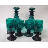 A pair of green glass decanters, globular shape with triple ring neck and facet cut mushroom shape