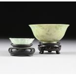 TWO CHINESE CARVED GREEN JADE BOWLS, MODERN, with a mottled light green jade tea bowl of tapering