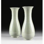 A PAIR OF CHINESE CELADON VASES, each of shaped baluster form with long flaring neck and rounded