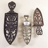 Three cast iron trivets with scrollwork decoration, all for spirit irons