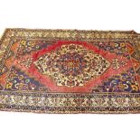 A large Persian style rug of medallion design on a red ground - 11.5 x 6.5ft