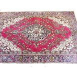 A Persian Tabriz carpet with multicoloured medallion design on a red ground - 290xm x 190cm