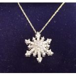 A 9 carat white gold snowflake pendant on fine gold chain