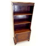 A 1920's small oak beaded bookcase with cupboard under