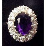 An 18ct gold diamond and amethyst oval cluster ring