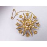 An Edwardian 9 carat gold and seed pearl star form brooch/pendant with safety chain