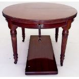 A Victorian circular wind out dining table with single interleaf all raised on reeded supports,