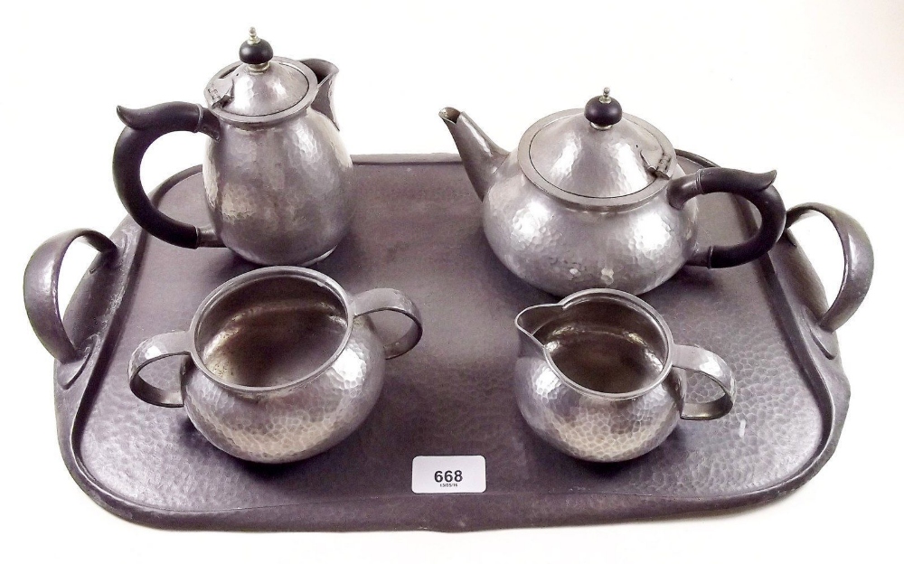 A Liberty Tudric pewter four piece hammered teaset No 01075 and matching tray No. 043 designed by