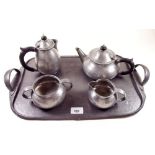 A Liberty Tudric pewter four piece hammered teaset No 01075 and matching tray No. 043 designed by