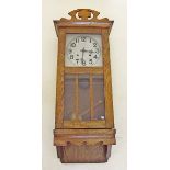 An early 20th century oak glazed wall clock