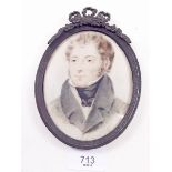 An oval early 19th century miniature watercolour portrait of a young man, signed indistinctively, in