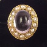 A Victorian gold ring set cabochon amethyst in seed pearl surround