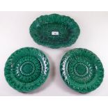 A set of eleven Wedgwood green Majolica Sunflower plates and a pair of Wedgwood vine leaf serving