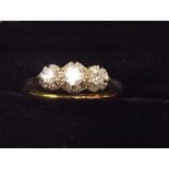 An 18 carat gold and platinum set three stone diamond ring