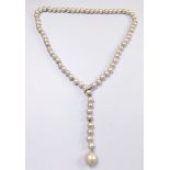 A grey freshwater pearl necklace with diamond set lariat clasp