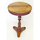 An early 19th century rosewood circular occasional table on baluster turned column and triple