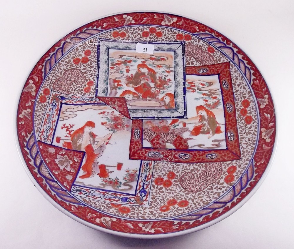 A large Japanese 19th century Imari charger with panels decorated seated craftsmen