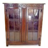 An oak two door glazed and carved bookcase