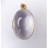 A Victorian egg form magnifying glass locket mounted in yellow metal