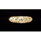 An 18 carat gold ring set five graduated diamonds interspersed with chip diamonds