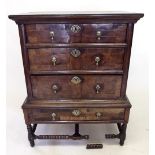 An 18th century elm and walnut chest of three drawers, with further drawer to stand, all raised on
