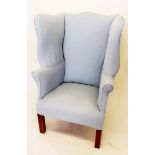 A George III style wing armchair upholstered in blue