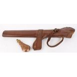 Tan leather shotgun saddle holster together with a reproduction .44 Colt copper and brass powder