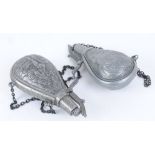 Two copy die cast powder flasks with embossed decoration
