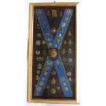 Royal Scots and other regiments cap and belt badge display board, framed & glazed, a total of 56