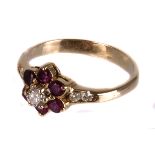 A ruby and diamond flower cluster ring,  the central brilliant within a ruby surround, to