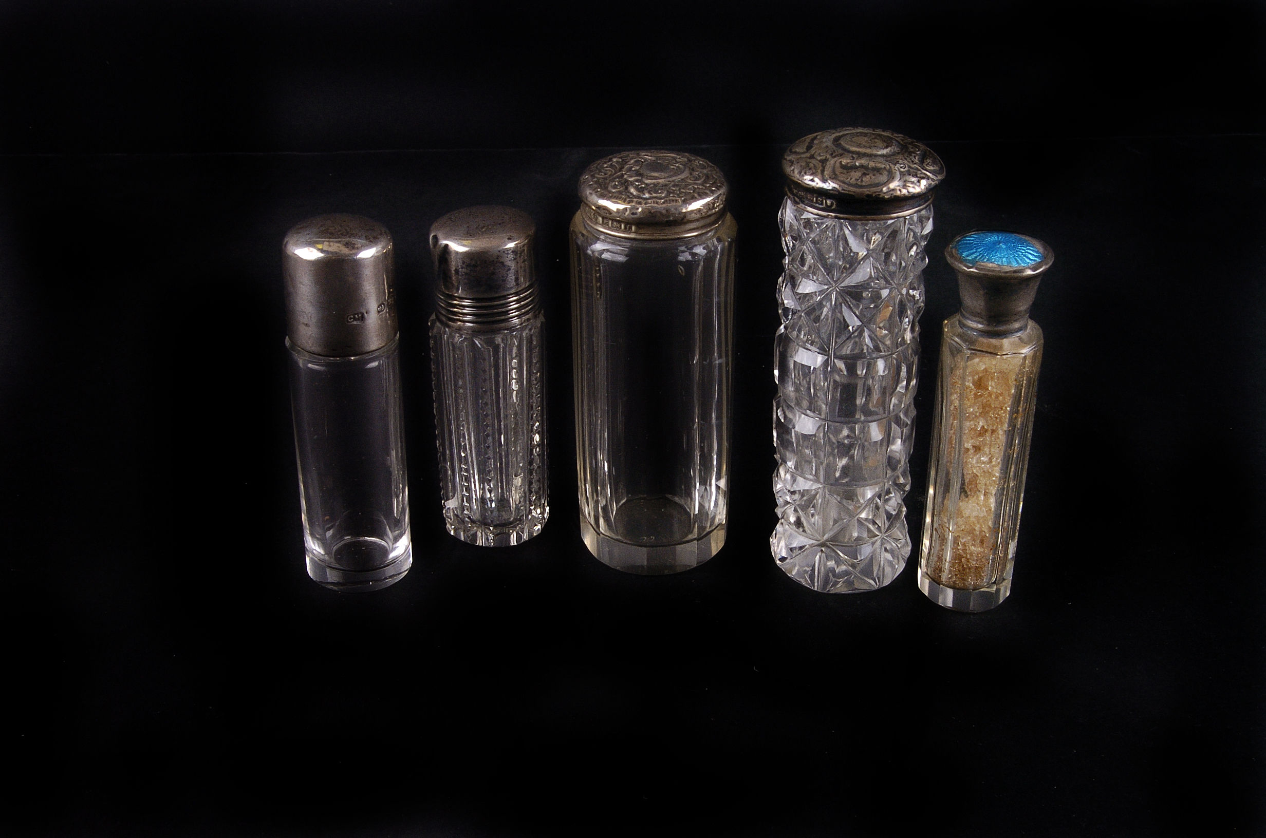 A group of early 20th century silver capped or collared scent bottles,  each of cylindrical form (5)