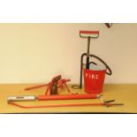 A collection of fire related items, including a red painted bucket, a stake, a pump, a blow torch