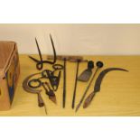 A collection of farming and farm yard tools, including sickles, borers, pinchers, a mattock and more