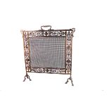 An Victorian metal fire screen, with ornate pierced frame and mesh centre on two tripod supports