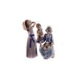 Three Lladro figure groups of young ladies , plus a Nao figure of a boy with puppy (4) The girl in