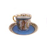 A 19th century Sevres cabinet cup and saucer, with Napoleonic cypher flanked by cherubs to a bleu