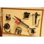 A group of seven vintage animal traps, mounted on a board, examples of a crow trap, a mole trap, a