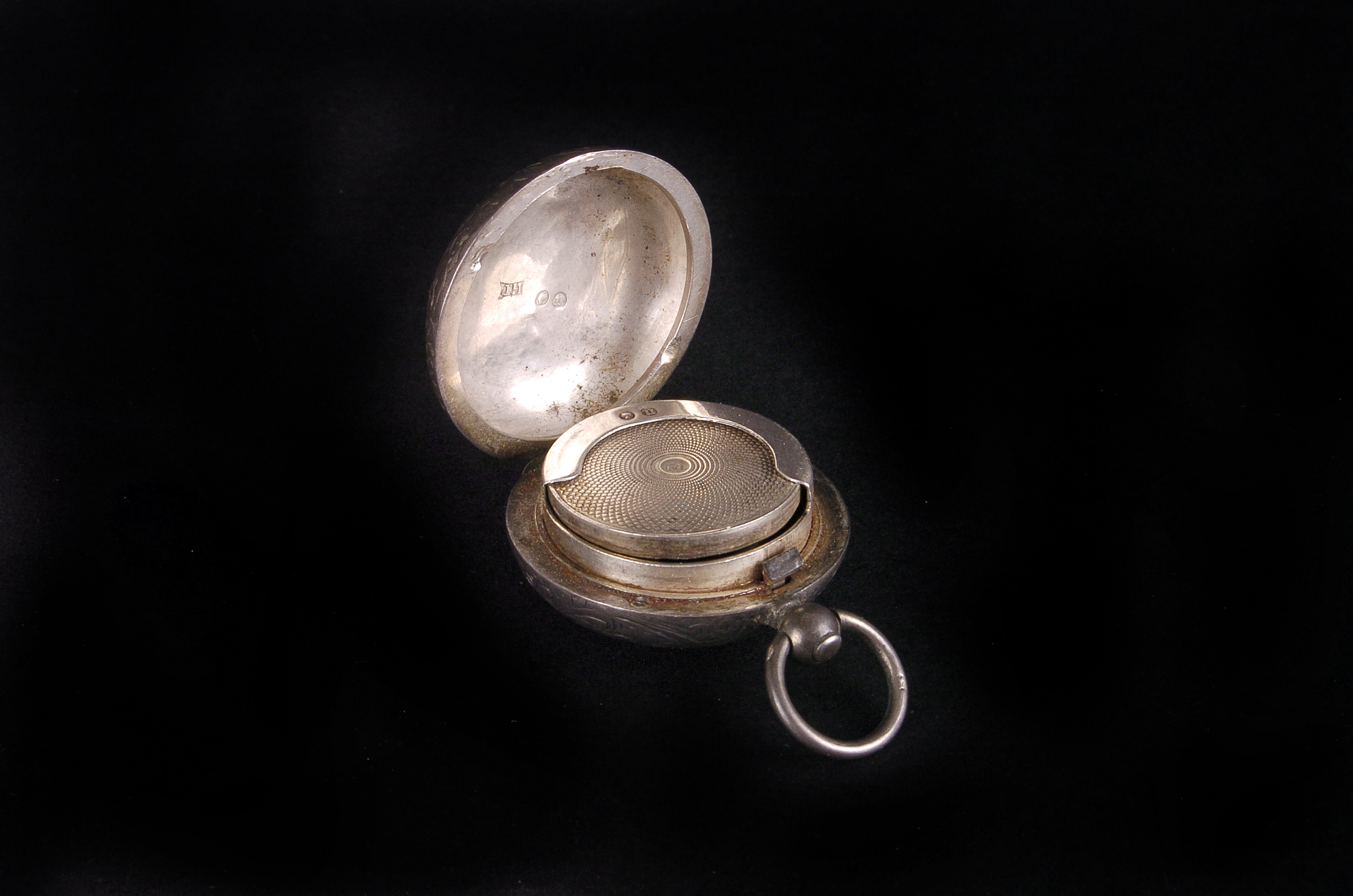 A Victorian silver fob sovereign holder, the circular case with engraved scrolling foliage, dated