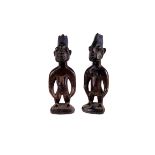 A pair of Nigerian Yoruba Ibeji twin figures, in the male and female form, the five point coiffure