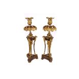 A pair of Regency bronze candleholders, the neo-classical form with triform bases having griffin